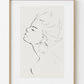 Framed line art of a profiled face on a white wall