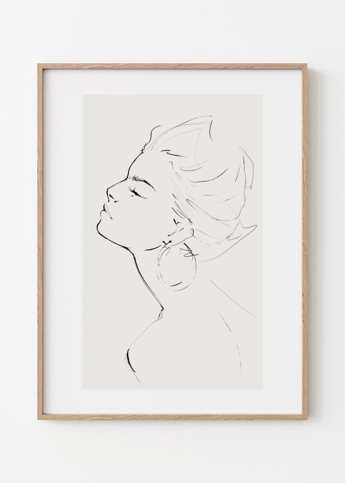 Framed line art of a profiled face on a white wall