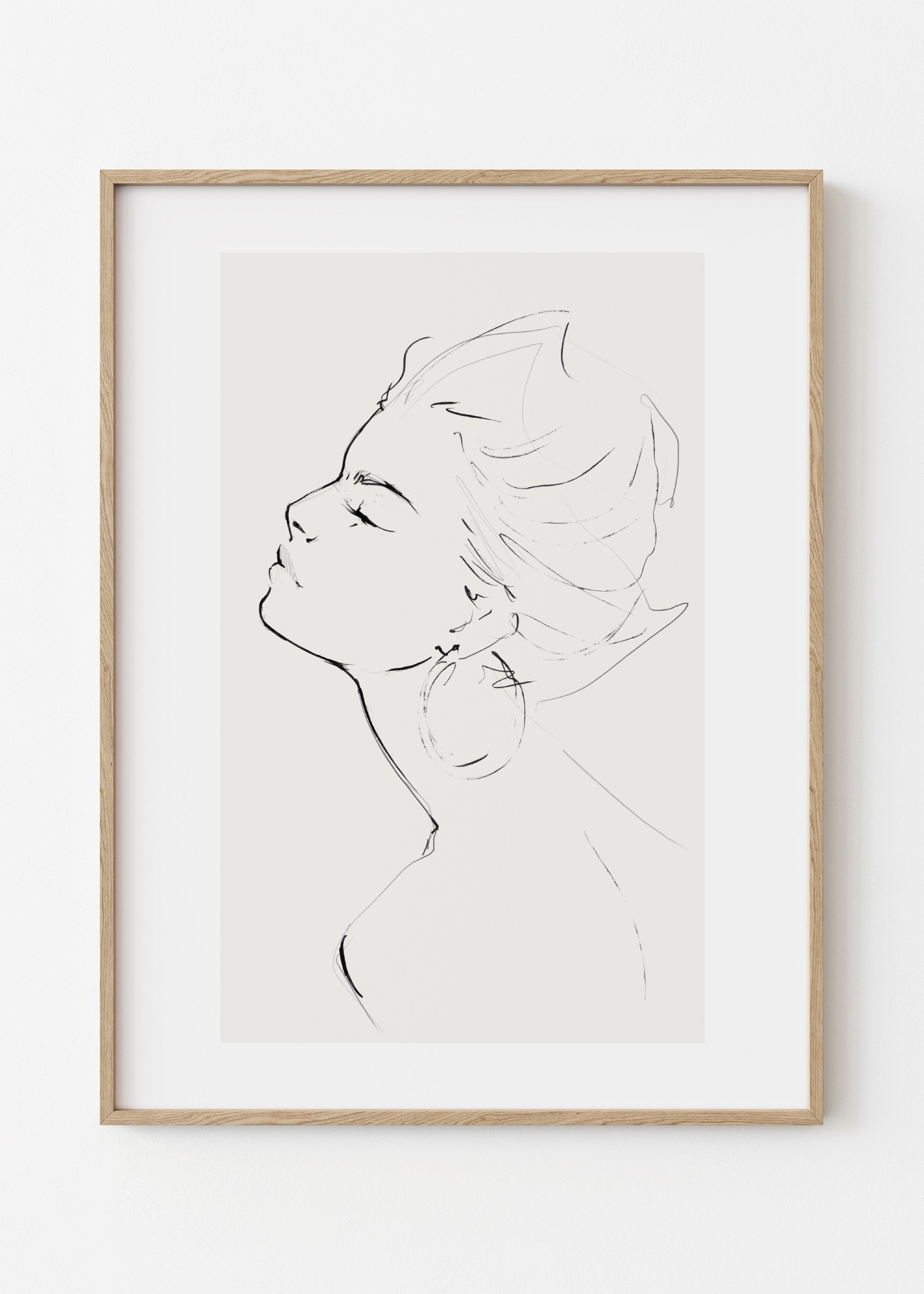 Framed line art of a profiled face on a white wall